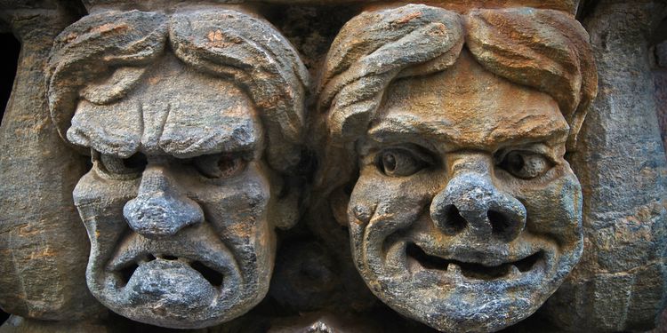 Photo of a stonewall carvings showing tragedy and comedy faces