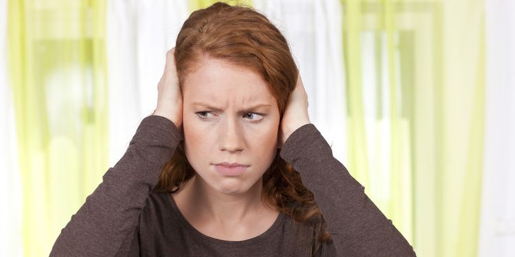 Photo of a woman holding her head experiencing spinning feeling