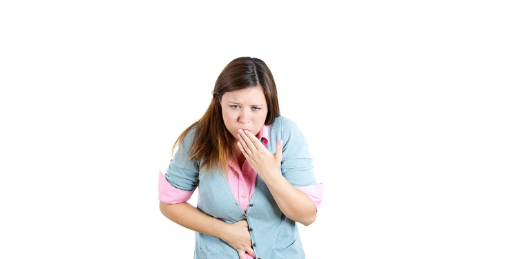 Photo of a woman holding her mouth not to vomit