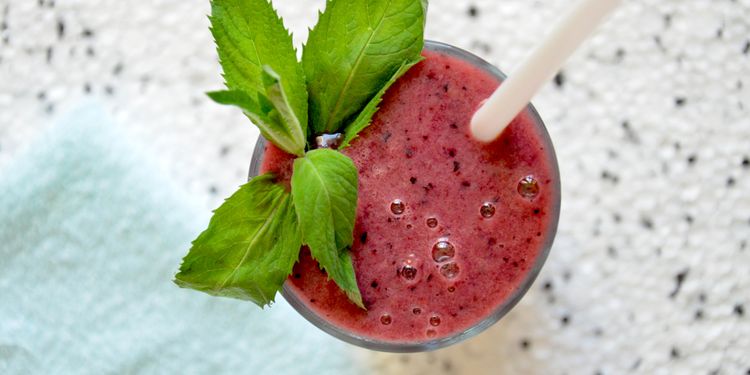 Photo of watermelon berry smothie in a glass with straw