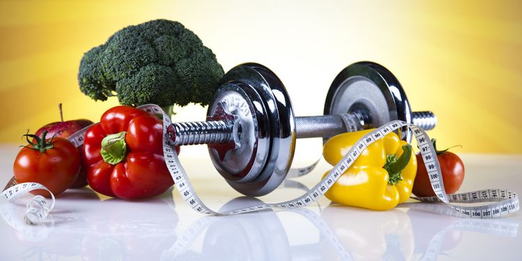 Photo of a weight set surrounded by raw vegetables 