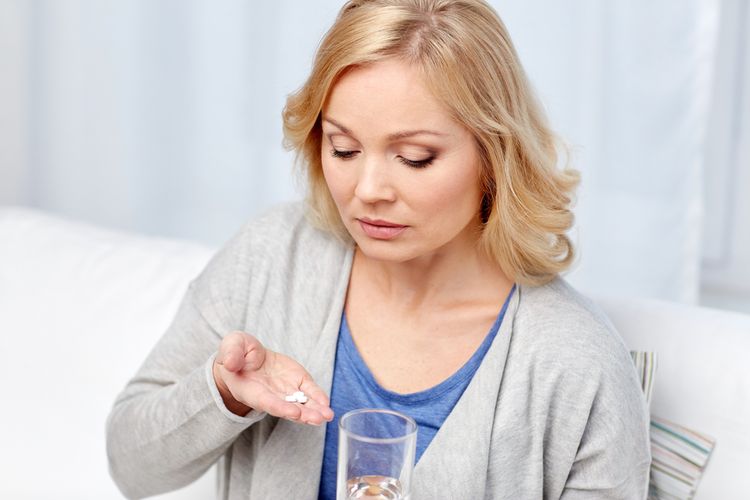 Photo of a Woman Taking Pills