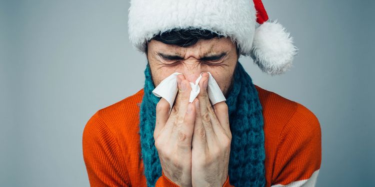 Photo of a sneezing man in a Santa Claus Suit