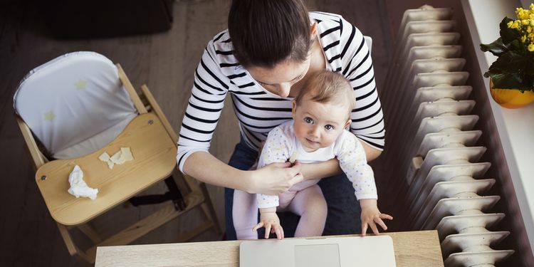 Photo of a young mother in home office with a baby